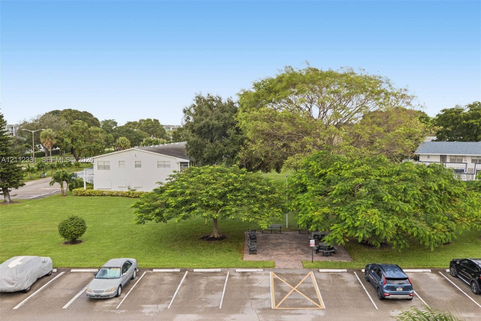 4025 Upminster K, #4025, Deerfield Beach, FL 33442 Expansive grounds featuring a manicured lawn, mature shade trees, and a paved common area