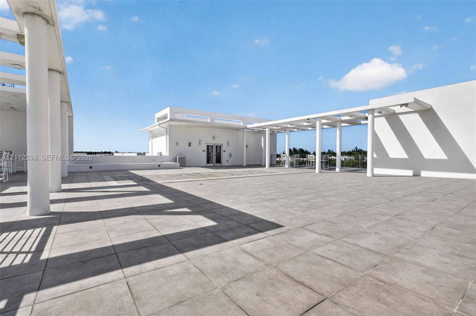 10305 NW 63rd Terrace, #102, Doral, FL 33178 Expansive rooftop terrace featuring large-format tile flooring and multiple structural pergolas supported by cylindrical columns