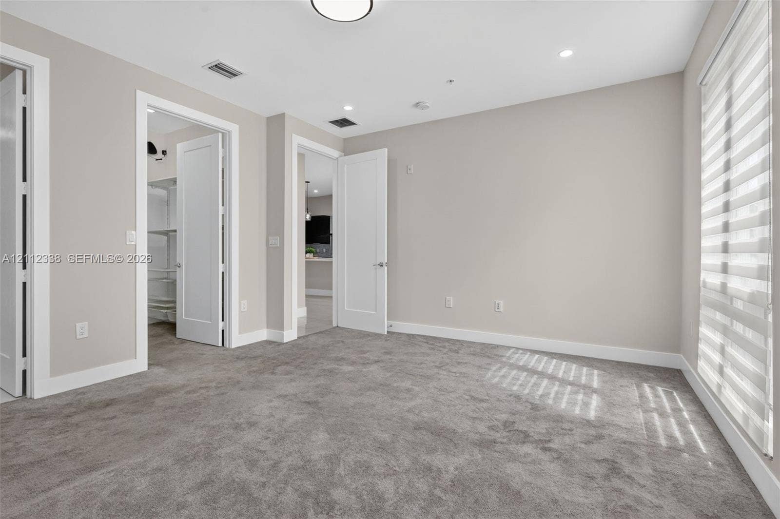 10305 NW 63rd Terrace, #102, Doral, FL 33178 Neutral-toned interior featuring wall-to-wall carpeting, shaker-style doors, recessed lighting, and tiered window shades