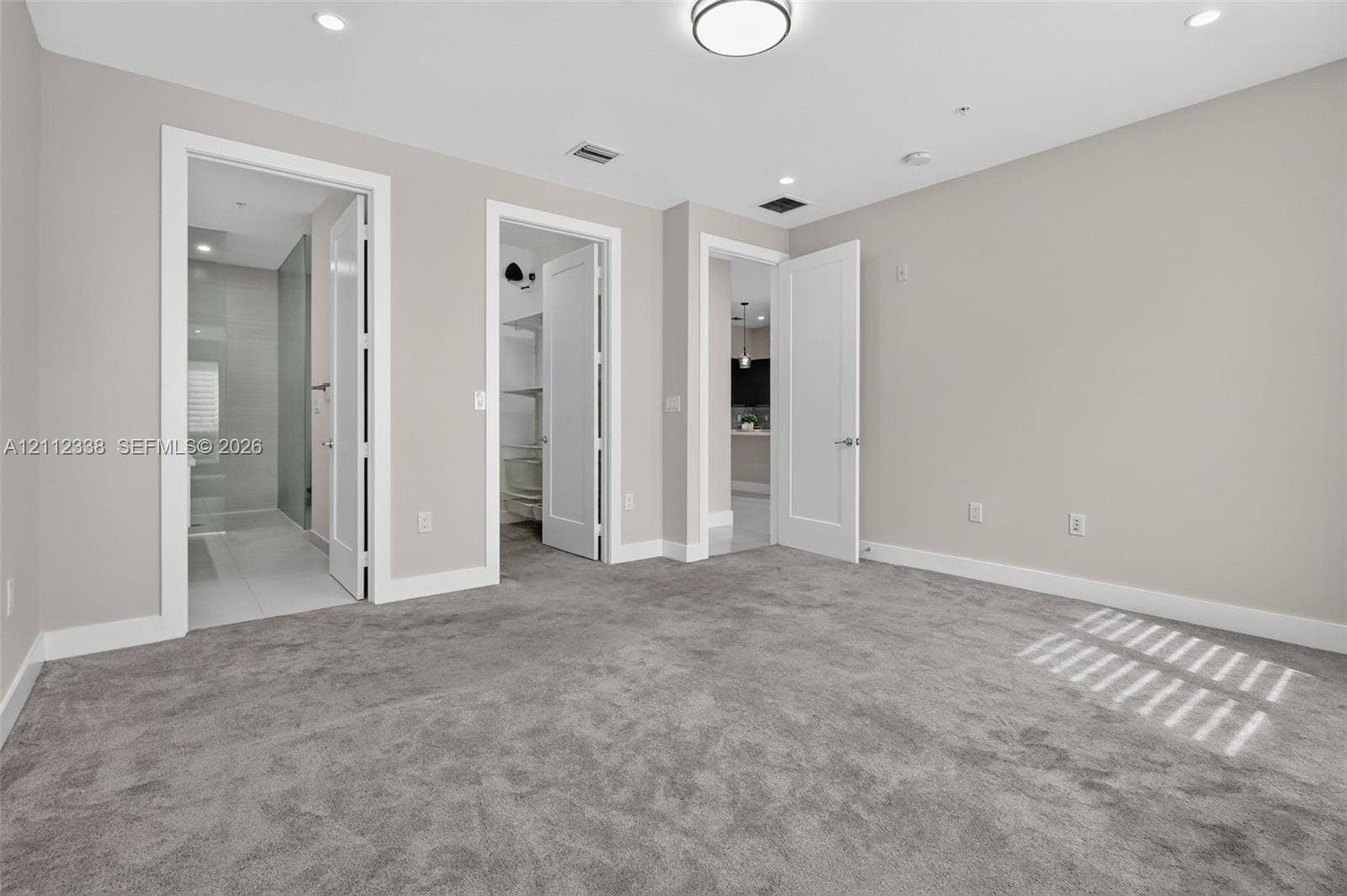 10305 NW 63rd Terrace, #102, Doral, FL 33178 Interior room featuring neutral wall tones, plush wall-to-wall carpeting, recessed LED lighting, and multi-panel shaker-style interior doors