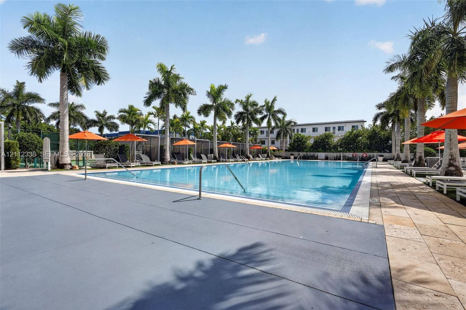 10305 NW 63rd Terrace, #102, Doral, FL 33178 Swimming pool with tiled decking, metal handrail, and palm tree landscaping