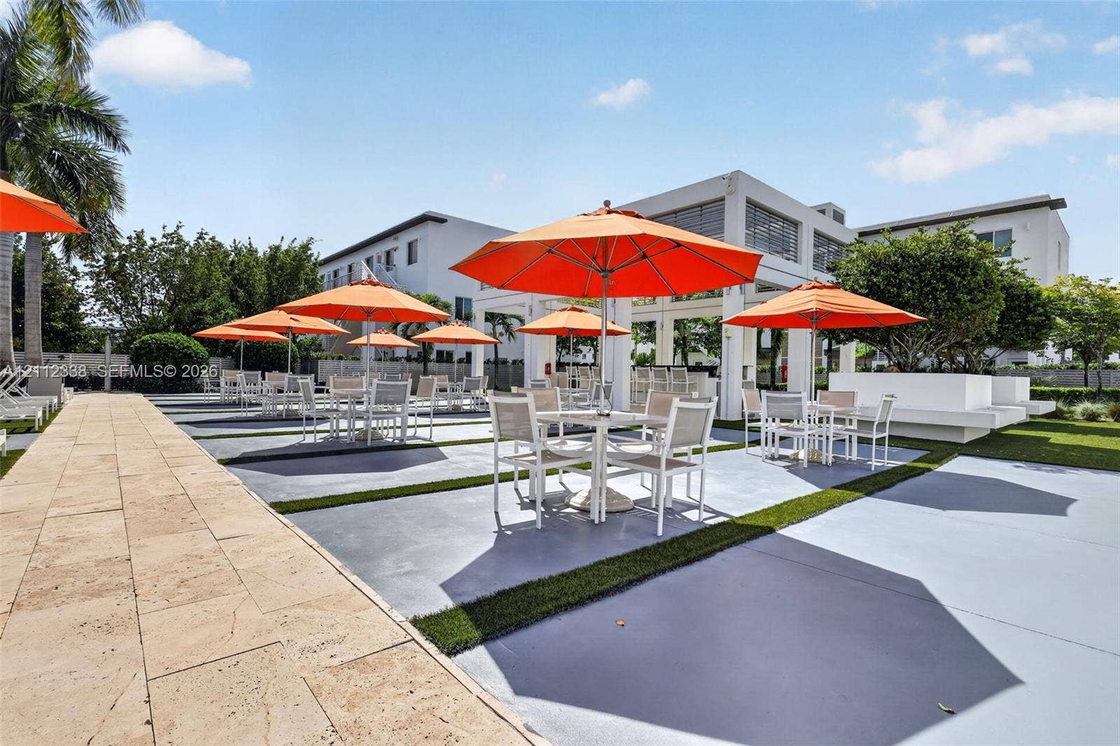 10305 NW 63rd Terrace, #102, Doral, FL 33178 Outdoor recreation area featuring a paved stone walkway, hardscaped patio surface with synthetic grass inlays, and an open-air covered pavilion
