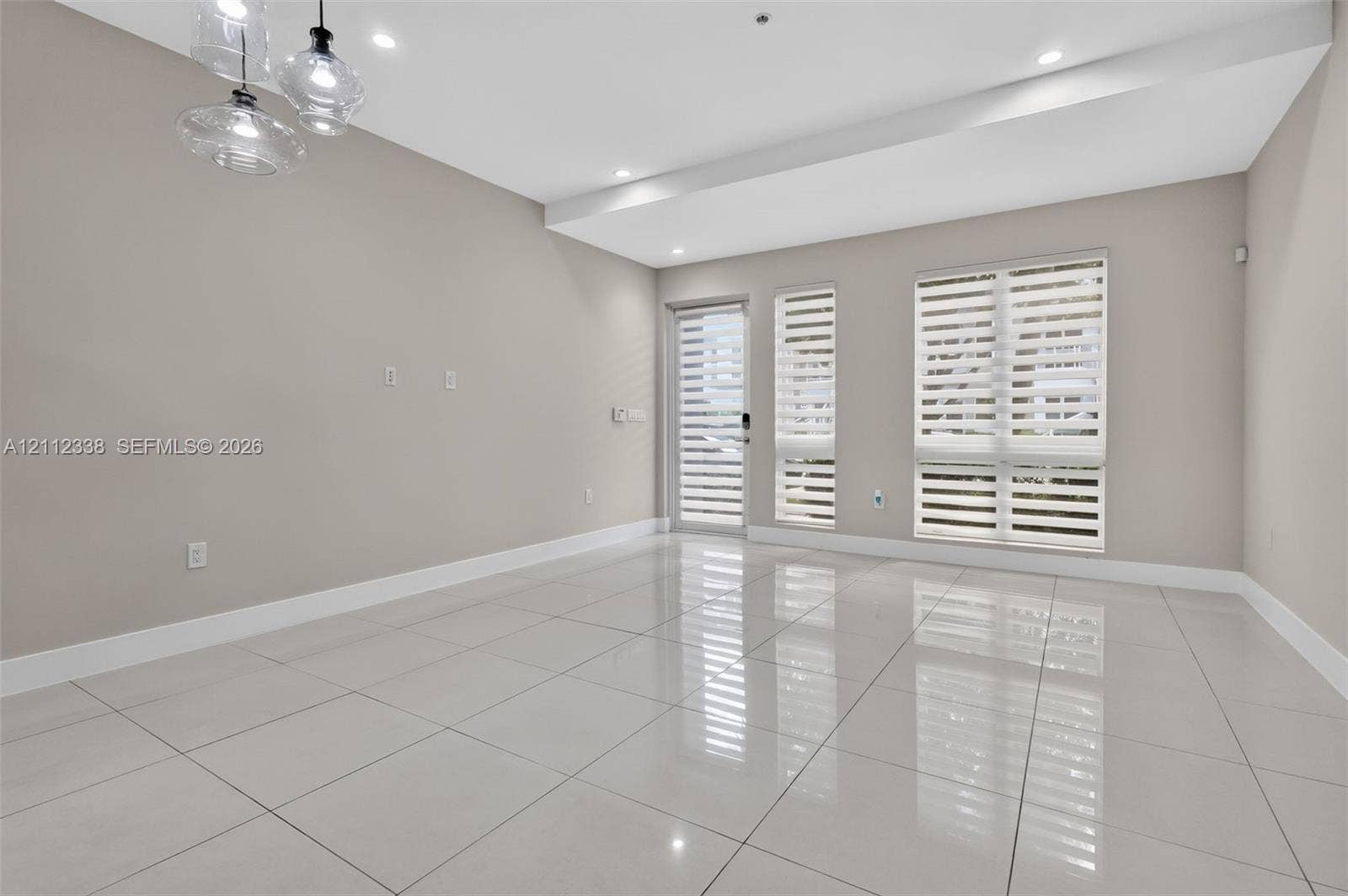10305 NW 63rd Terrace, #102, Doral, FL 33178 Large-format polished tile flooring, recessed ceiling lighting, multi-pendant glass light fixture, and windows featuring dual-layer horizontal blinds