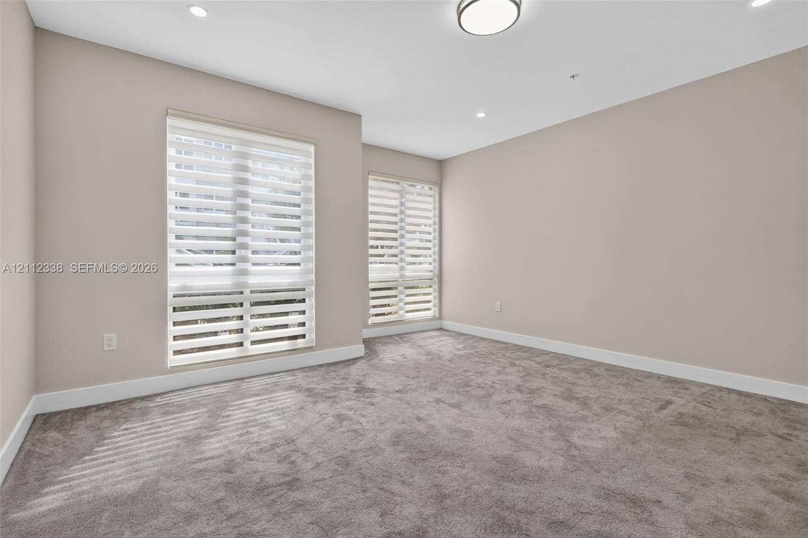 10305 NW 63rd Terrace, #102, Doral, FL 33178 Neutral interior featuring wall-to-wall carpeting, recessed lighting, and dual windows equipped with roller shades