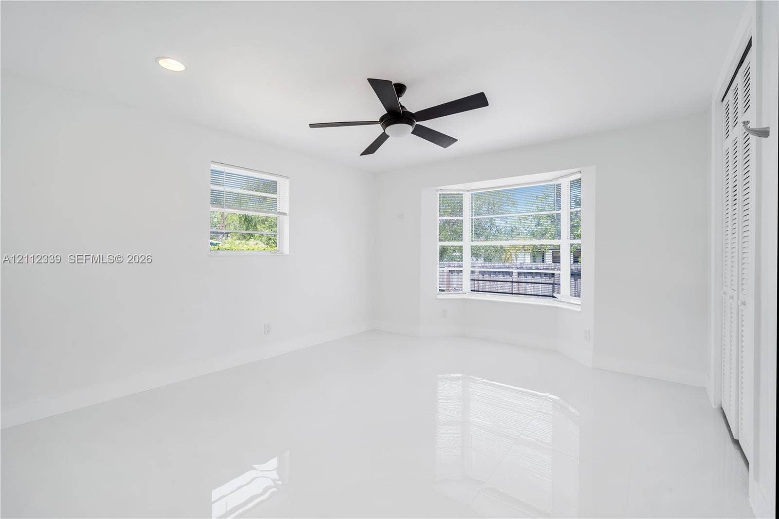 8901 SW 149th Terrace, #n/a, Palmetto Bay, Palmetto Bay, FL 33176 Bright interior featuring polished tile flooring, a bay window, recessed lighting, a ceiling fan, and louvered closet doors