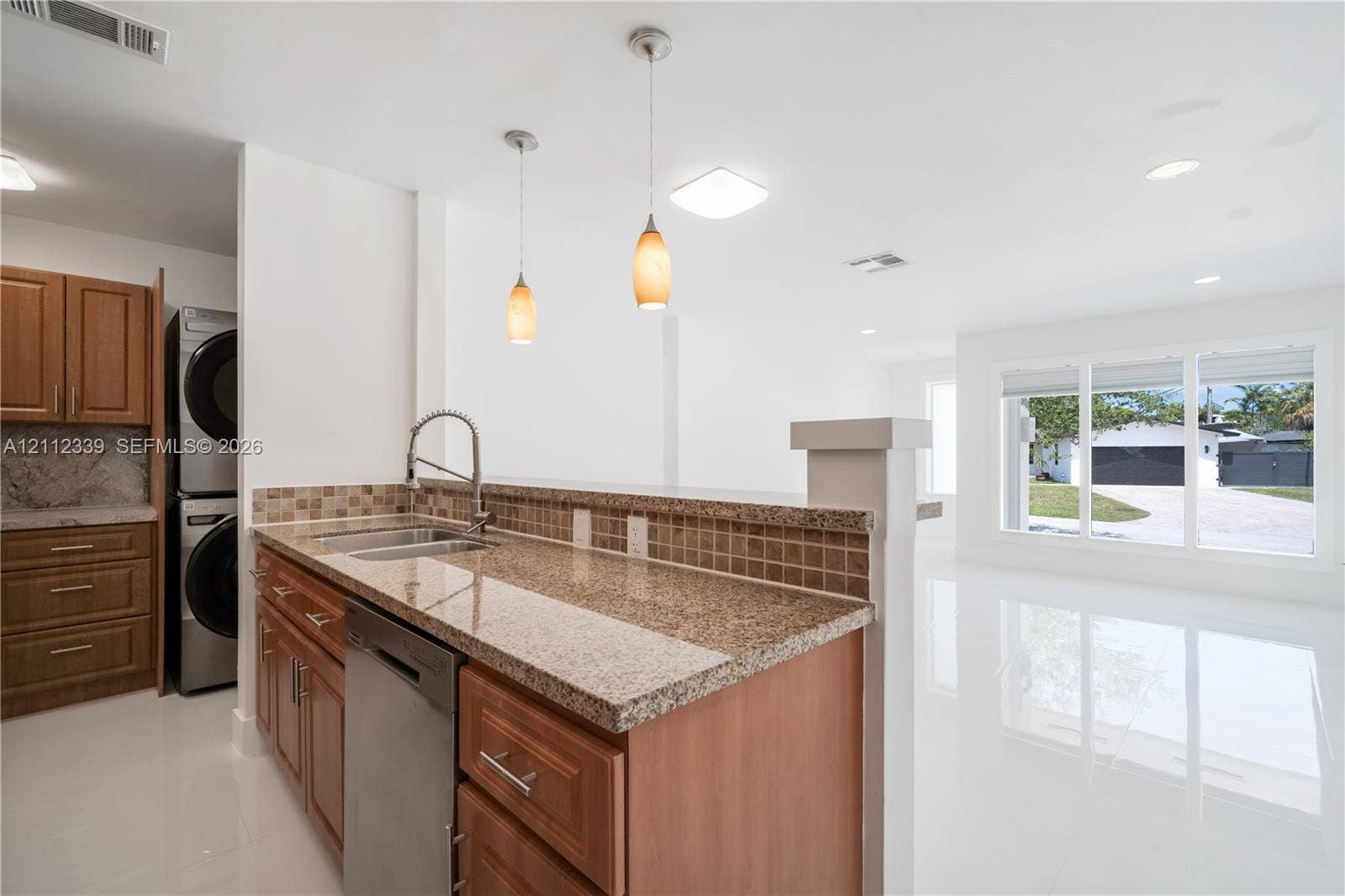 8901 SW 149th Terrace, #n/a, Palmetto Bay, Palmetto Bay, FL 33176 Kitchen featuring granite countertops, tile backsplash, stainless steel dishwasher, wood-finish cabinetry, and beautiful view to the living room and outdoors*