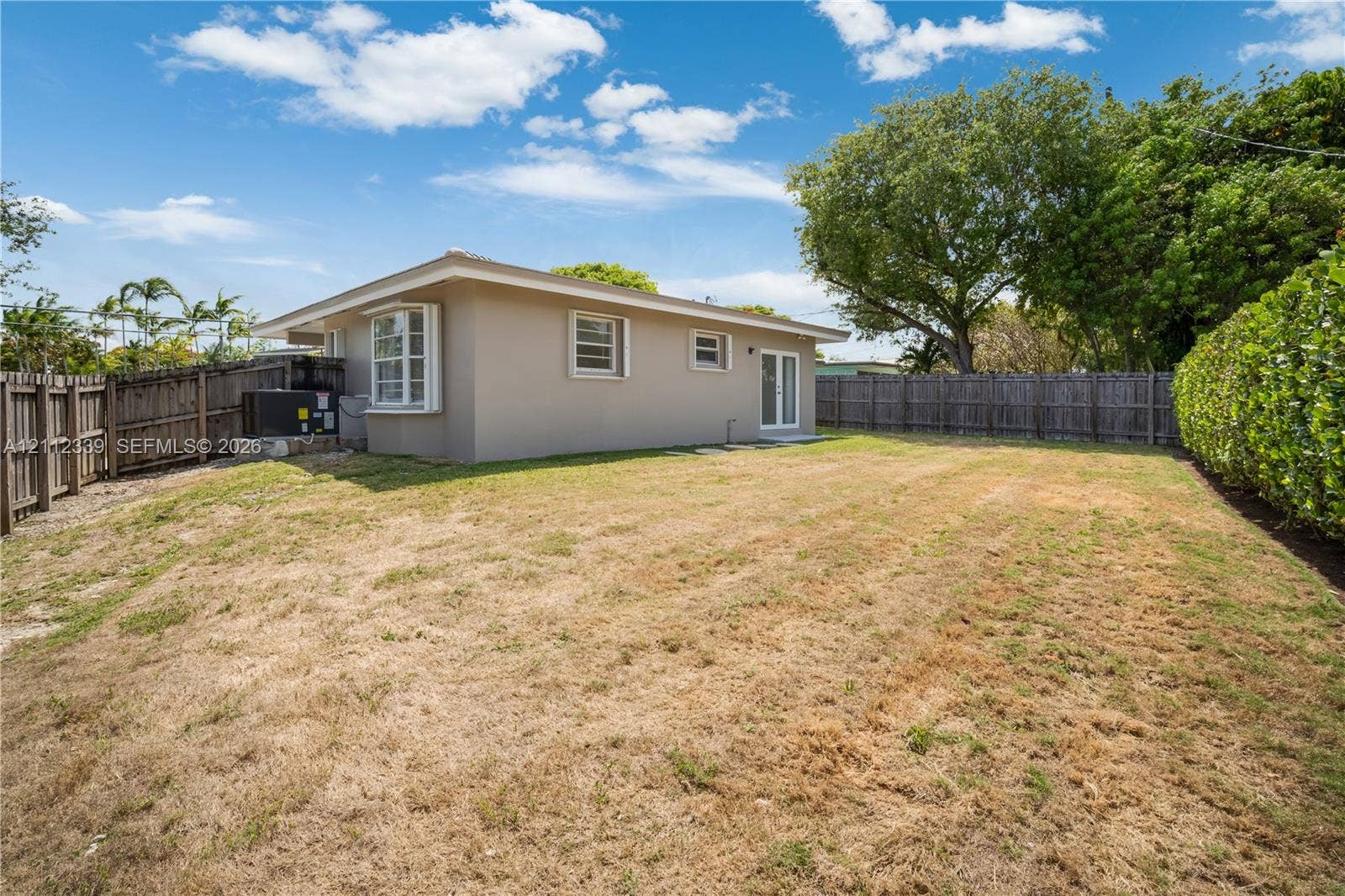 8901 SW 149th Terrace, #n/a, Palmetto Bay, Palmetto Bay, FL 33176 Backyard featuring a wood privacy fence, perimeter landscaping, and a new AC * Accordion shutters throughout *