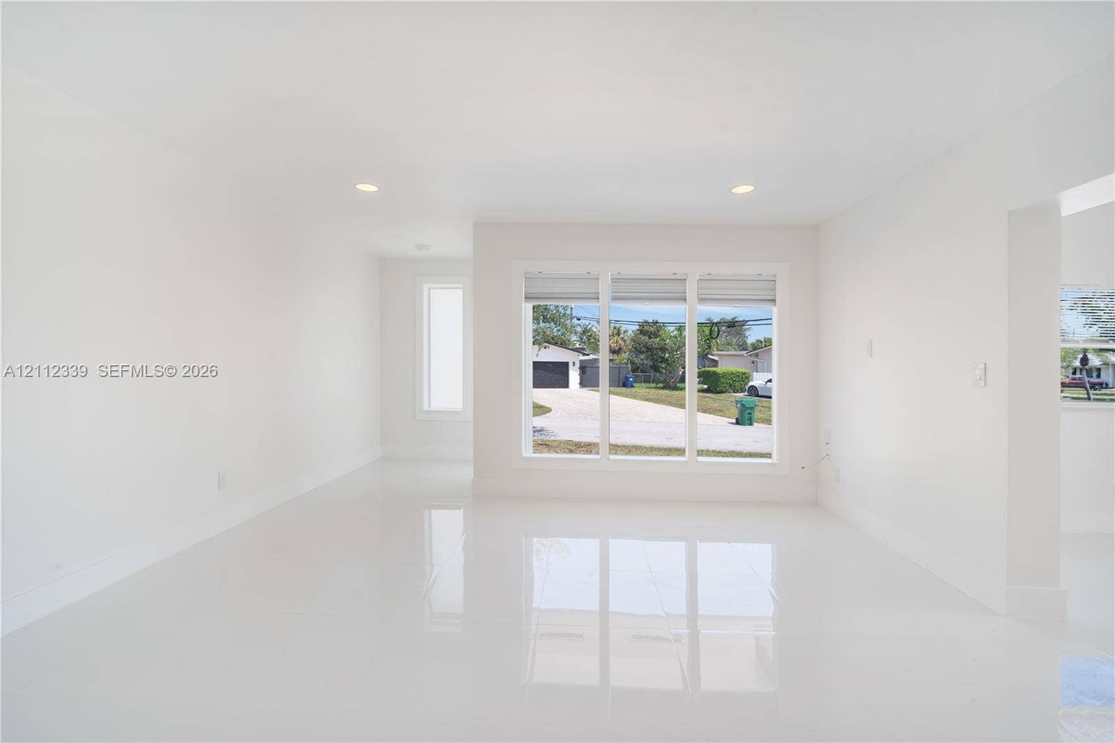 8901 SW 149th Terrace, #n/a, Palmetto Bay, Palmetto Bay, FL 33176 Open-concept interior featuring large-format polished tile flooring, recessed lighting, and a triple-pane picture window