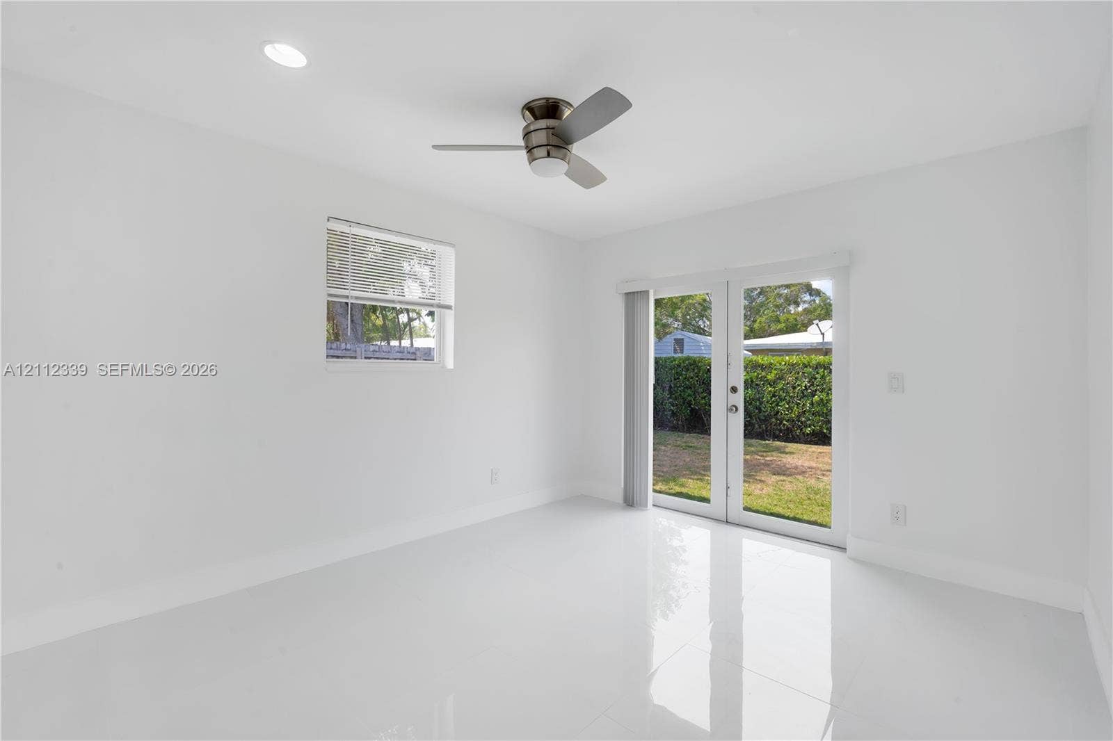 8901 SW 149th Terrace, #n/a, Palmetto Bay, Palmetto Bay, FL 33176 Glossy tile flooring, recessed lighting, ceiling fan, single-pane window, and glass-paned double doors leading to the backyard *