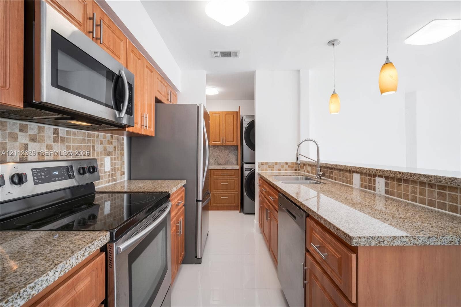 8901 SW 149th Terrace, #n/a, Palmetto Bay, Palmetto Bay, FL 33176 Kitchen featuring wood cabinetry, granite countertops, stainless steel appliances, tiled backsplash, and pendant lighting * Newer stainless steel appliances *