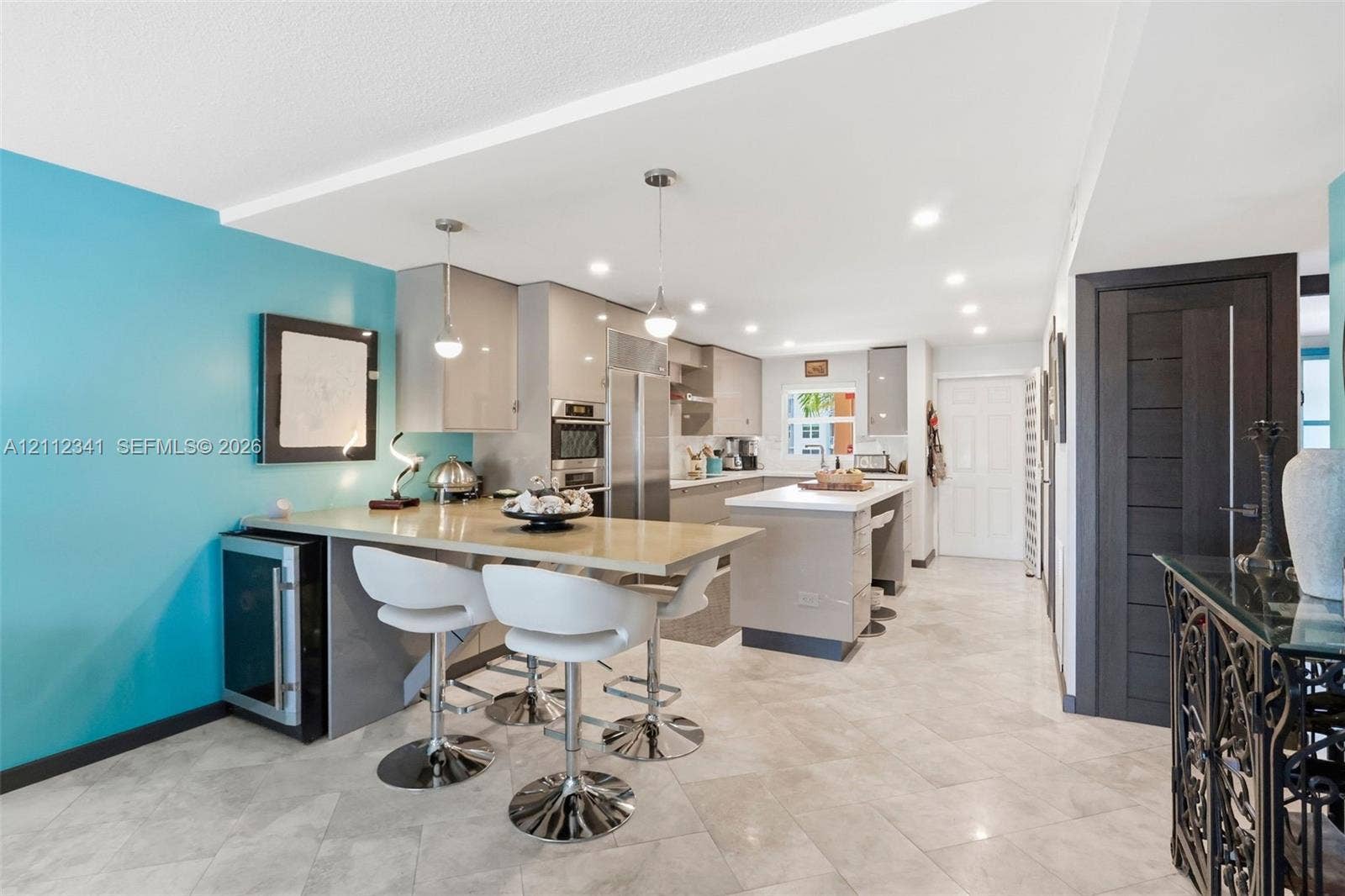 1617 SE 15th Street, #401, Fort Lauderdale, FL 33316 Kitchen featuring high-gloss cabinetry, stone countertops, a central island, recessed lighting, and tile flooring