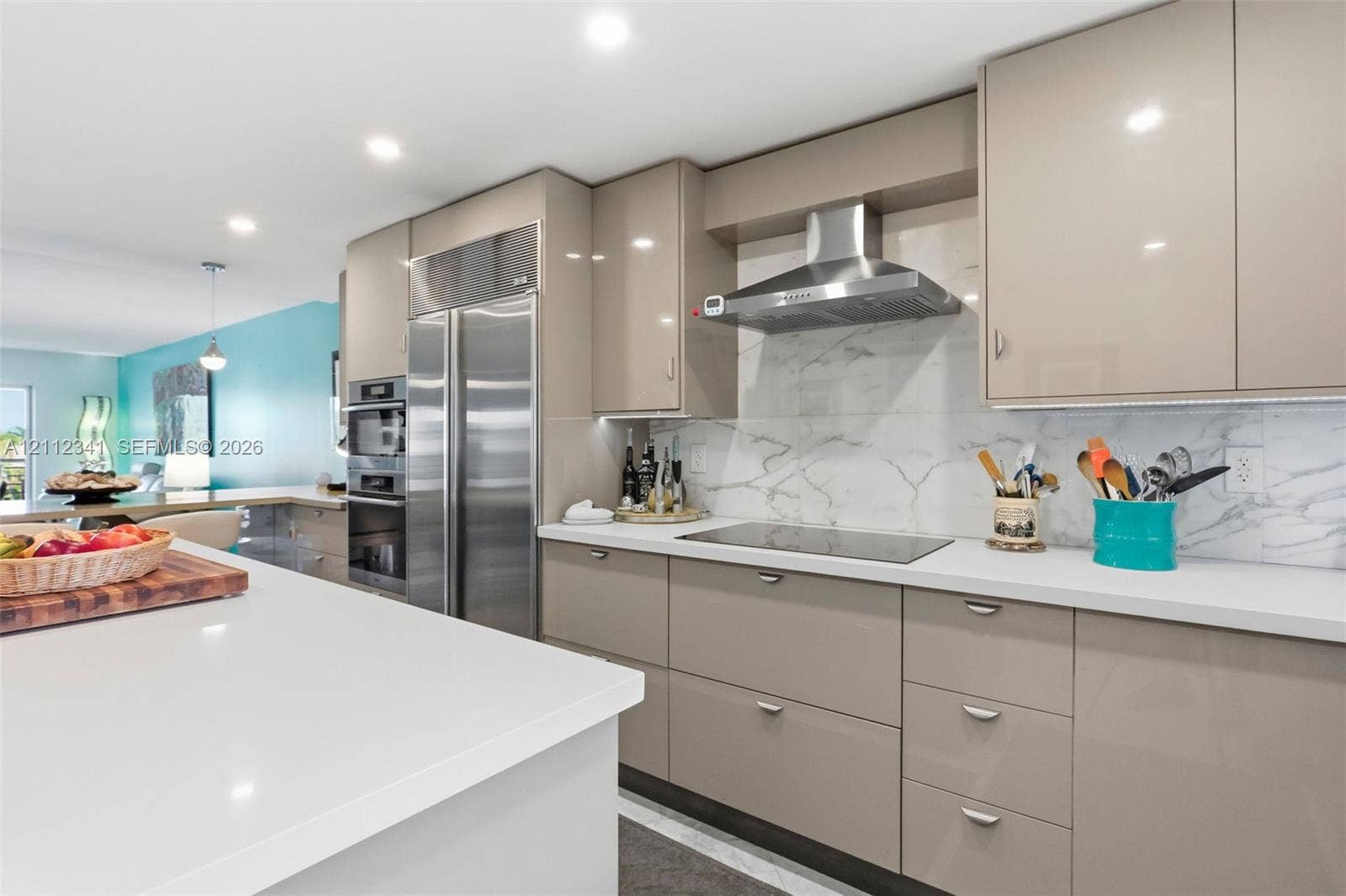 1617 SE 15th Street, #401, Fort Lauderdale, FL 33316 Kitchen featuring high-gloss cabinetry, stone-finish backsplash, quartz countertops, built-in stainless steel appliances, and recessed lighting