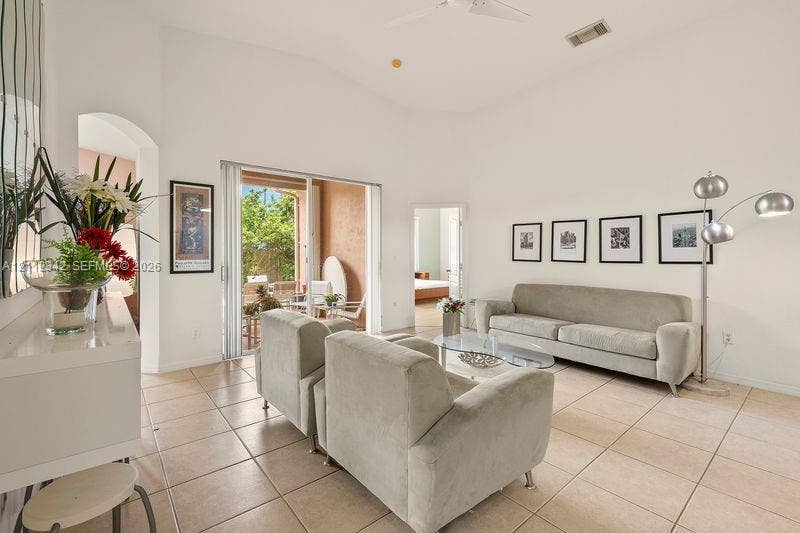Living area featuring vaulted ceilings, tile flooring, and sliding glass doors providing outdoor access