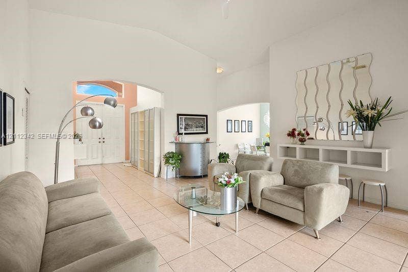 High ceilings, tiled flooring, arched entryways, and a wall-mounted built-in console