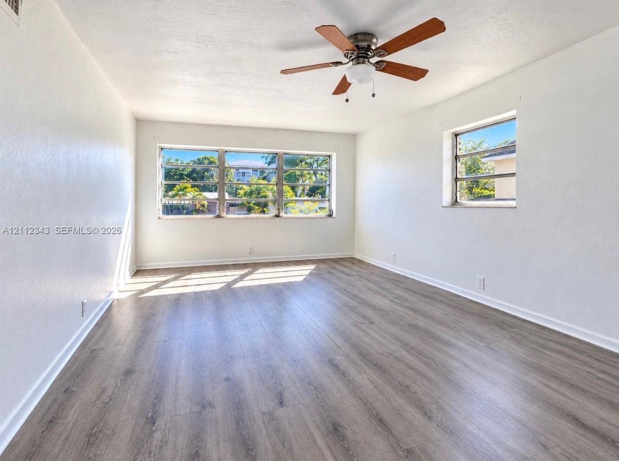 1477 SW 24th Court, #5, Fort Lauderdale, Fort Lauderdale, FL 33315 Wood-finish flooring, large multi-pane windows, and a ceiling-mounted fan with integrated lighting