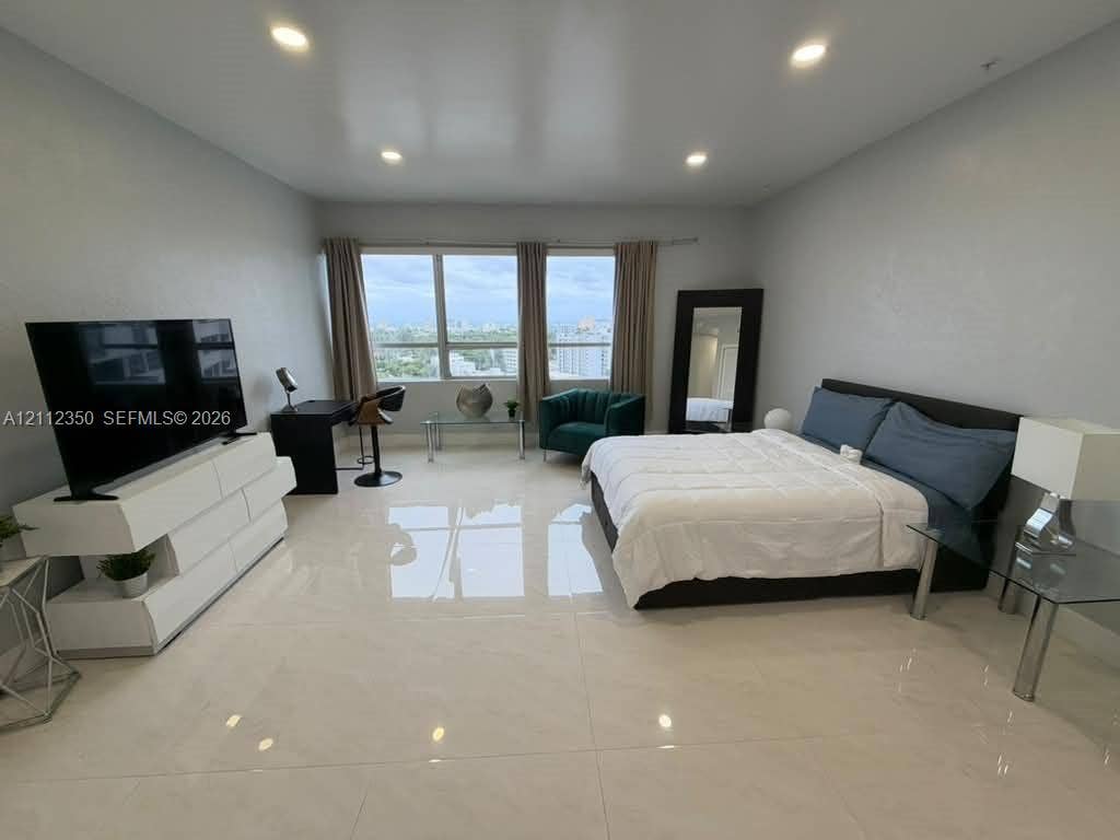 Large-format tile flooring, recessed ceiling lighting, and expansive windows featuring exterior horizon exposure