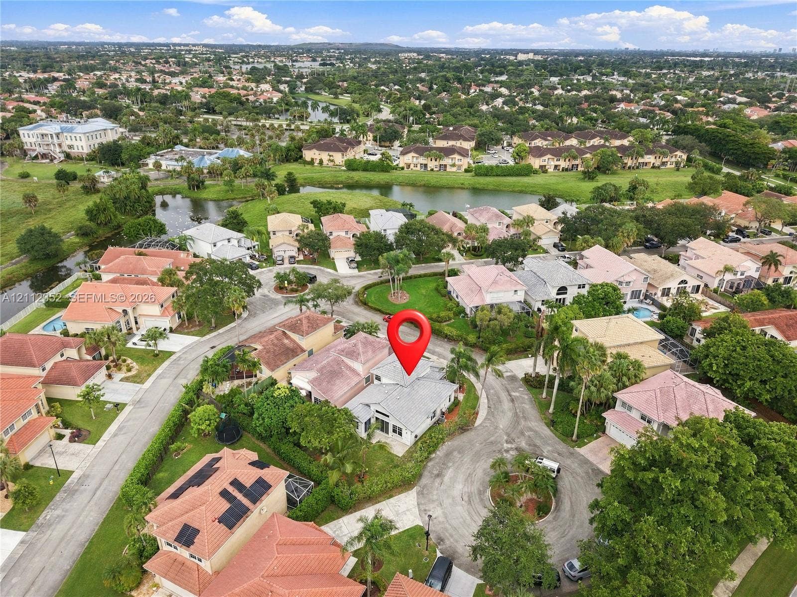 2880 NW 75th Avenue, Margate, FL 33063 Aerial perspective of a single-story residence situated within a cul-de-sac, featuring a shingle roof, paved driveway, and mature landscaping