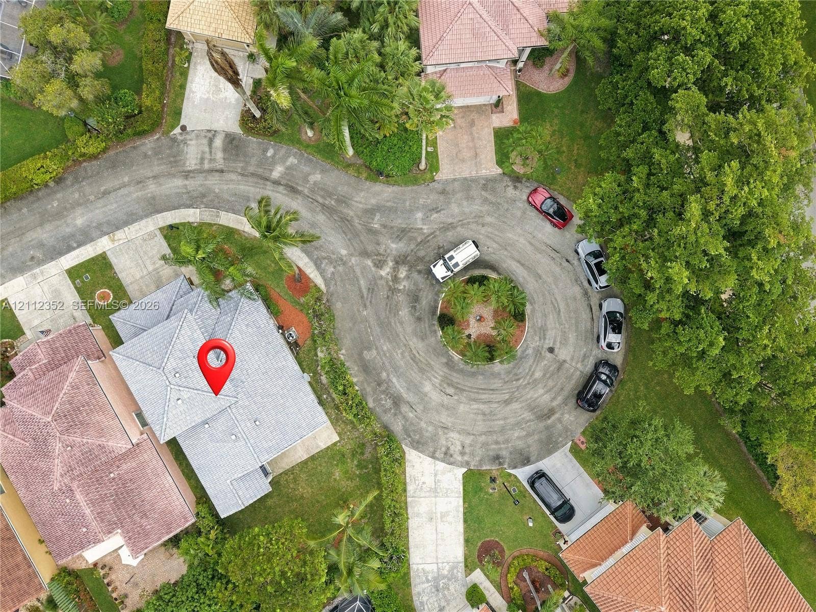 2880 NW 75th Avenue, Margate, FL 33063 Aerial view of a residential property situated on a cul-de-sac, featuring a shingled roof, concrete driveway, and landscaped surroundings