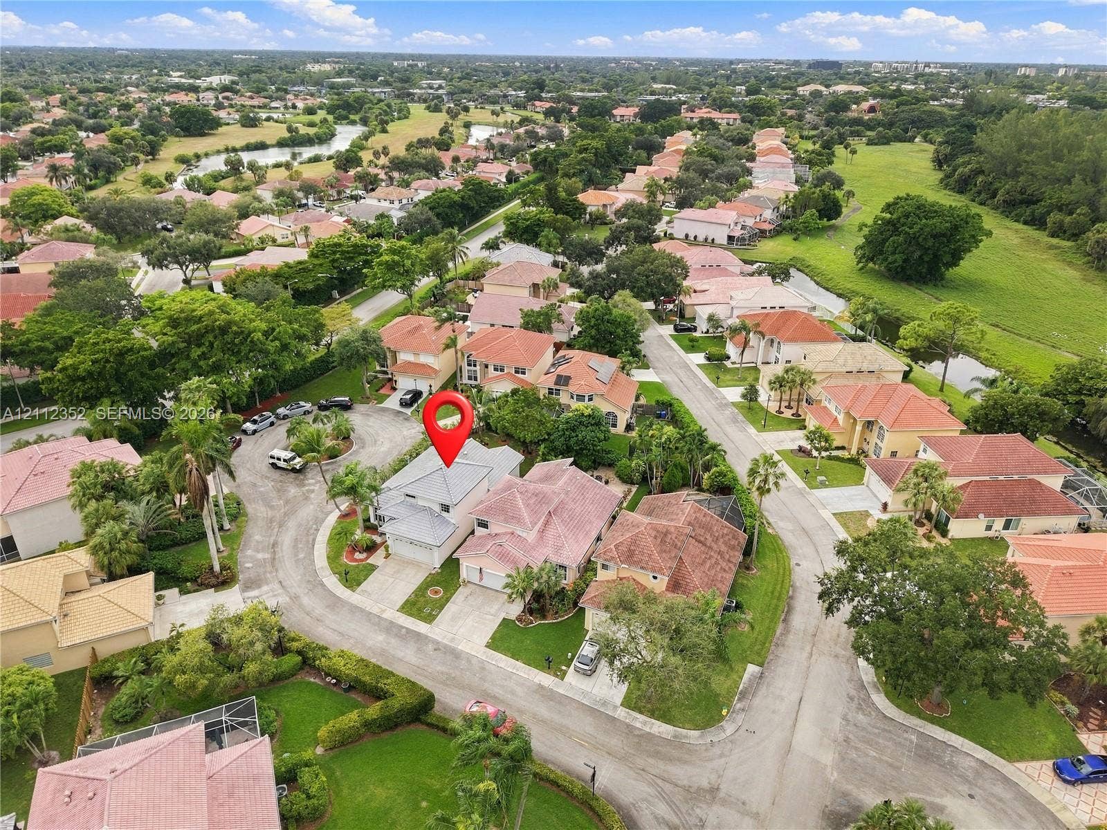 2880 NW 75th Avenue, Margate, FL 33063 Aerial perspective of a single-family residence situated on a cul-de-sac within a residential community featuring extensive green space and water features