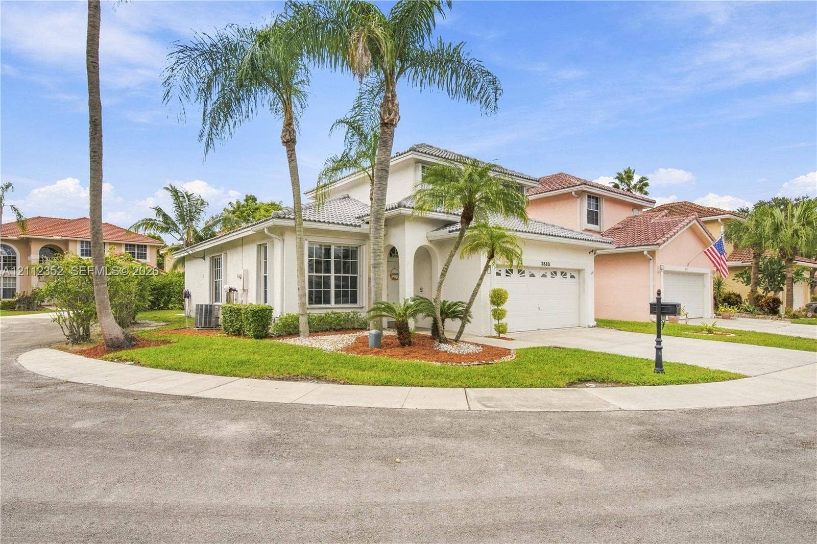 2880 NW 75th Avenue, Margate, FL 33063 Two-story stucco exterior featuring a tiled roof, arched entryway, multi-pane windows, and an attached two-car garage
