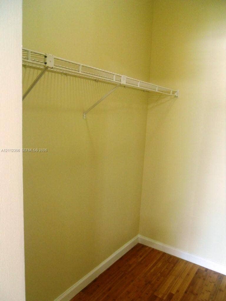 Storage area featuring wood-finish flooring and an integrated wire shelving system
