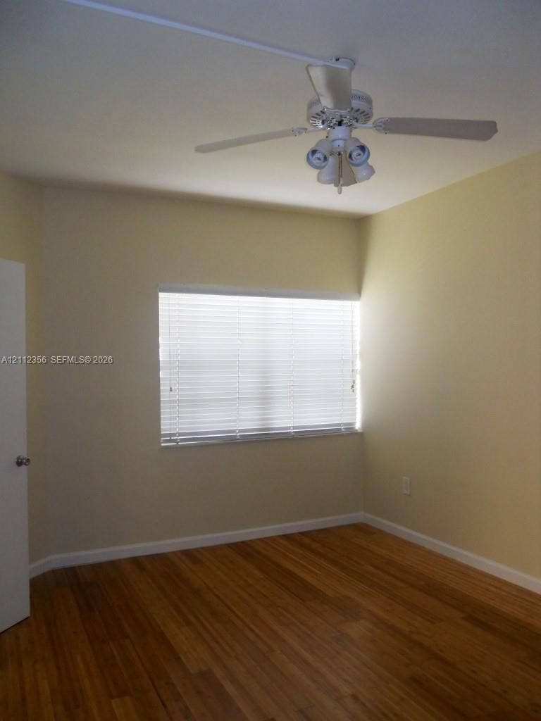 Neutral wall finishes, wood-finish flooring, horizontal window blinds, and a white ceiling fan with integrated light fixture