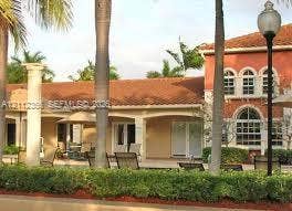 Stucco exterior featuring arched windows, a multi-paneled roof, covered outdoor loggia, and structural columns