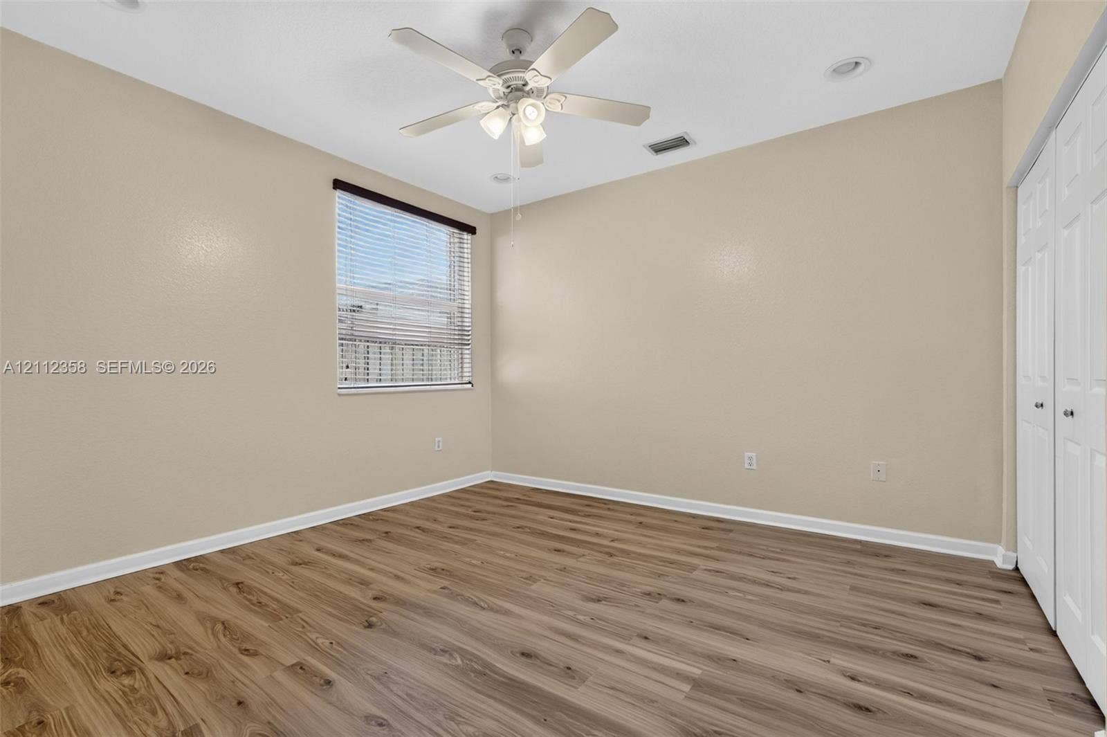 1611 SE 16th Street, Homestead, FL 33035 Ground floor Room featuring wood-finish flooring, a white ceiling fan with integrated lighting, recessed lighting, and white bifold closet doors