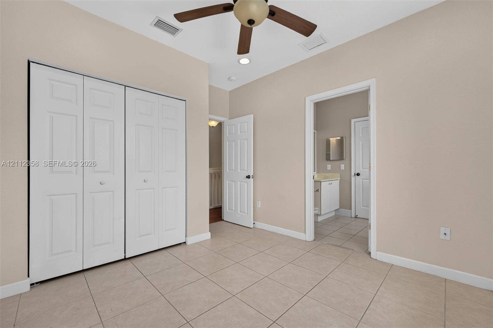 1611 SE 16th Street, Homestead, FL 33035 Room featuring neutral tile flooring, bi-fold closet doors, a multi-blade ceiling fan, and recessed lighting