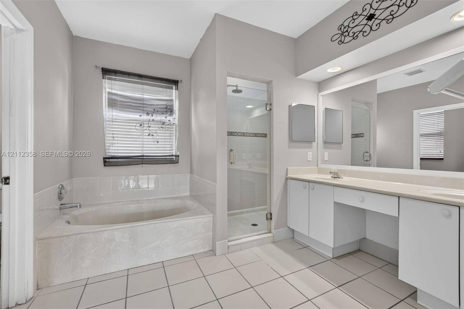 1611 SE 16th Street, Homestead, FL 33035 Bathroom featuring a tiled soaking tub with a tiled surround, a separate glass-enclosed shower, dual-sink vanity with white cabinetry, and recessed lighting
