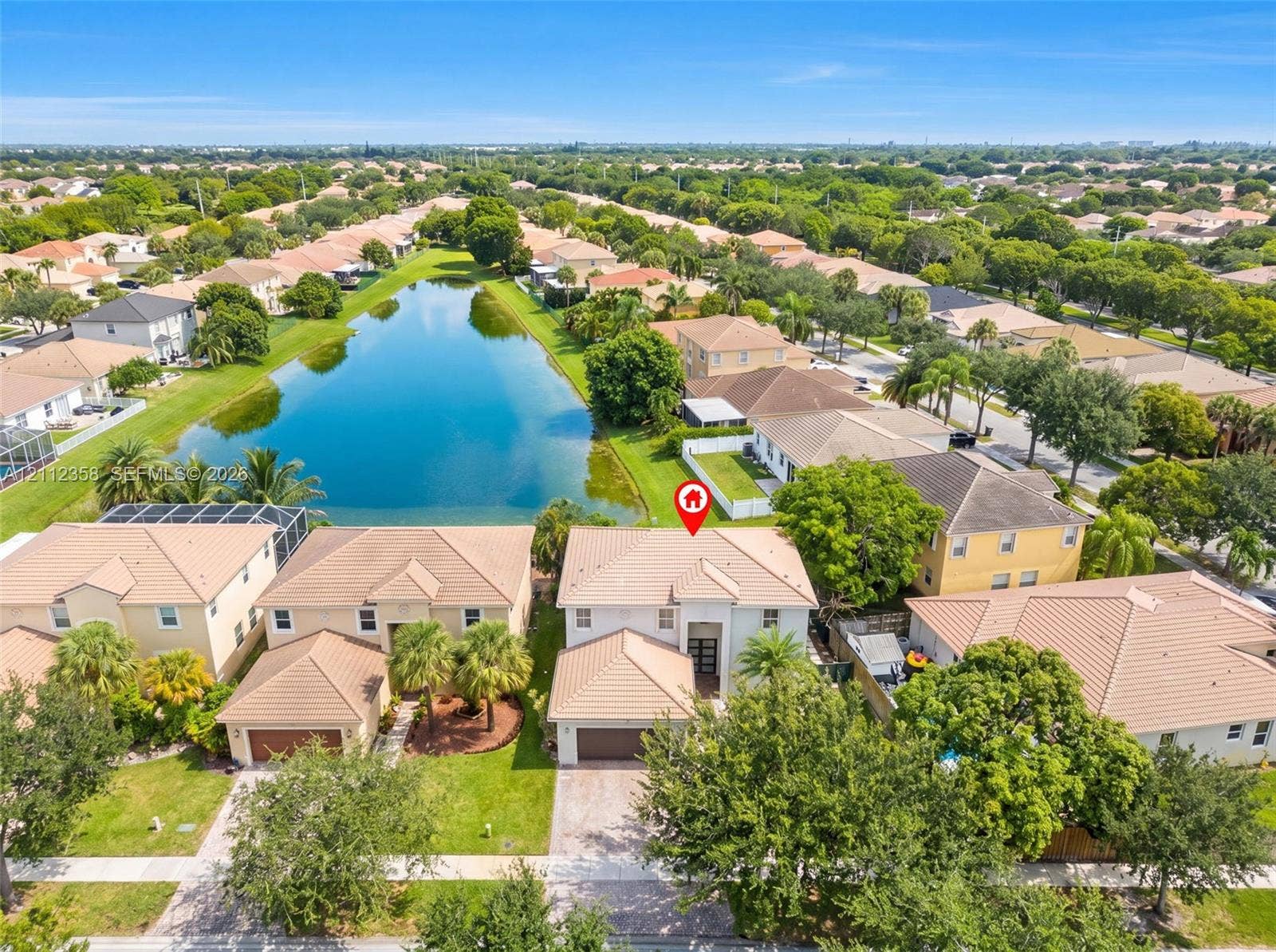 1611 SE 16th Street, Homestead, FL 33035 Aerial perspective featuring a two-story residence with a concrete tile roof, a multi-car garage, and proximity to a water feature