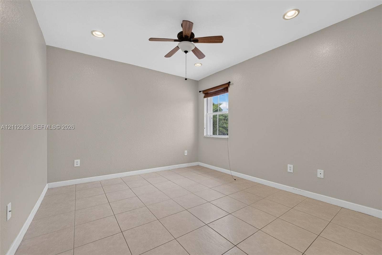 1611 SE 16th Street, Homestead, FL 33035 Neutral-toned room featuring large-format tile flooring, recessed lighting, a ceiling fan, and a single window with a wooden valance