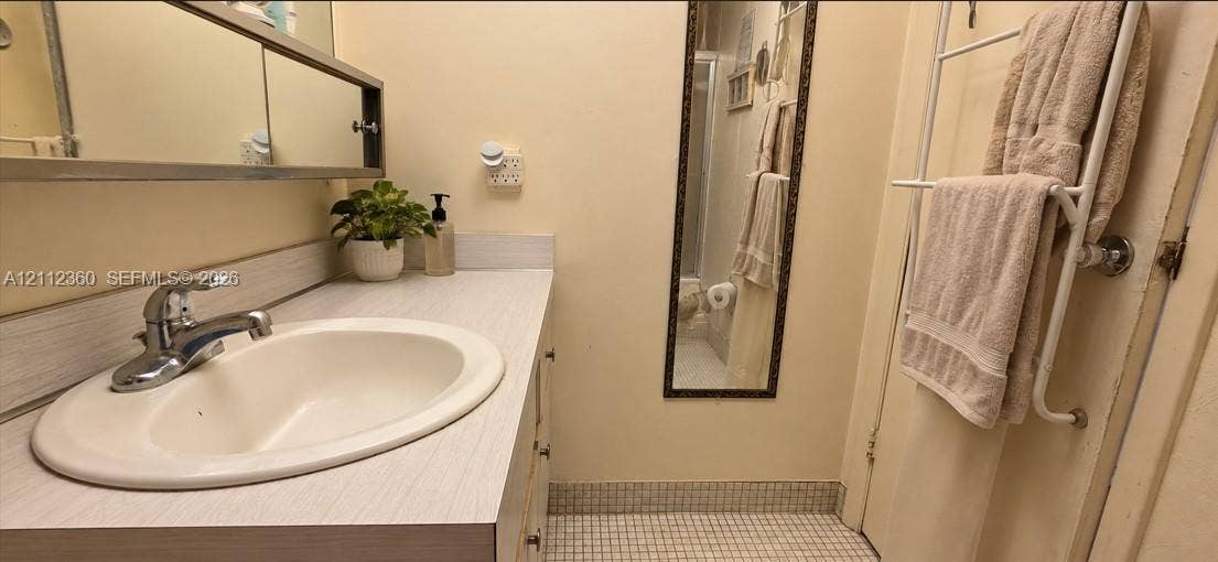 Vanity featuring a laminate countertop, integrated oval basin, chrome-finish faucet, and a wall-mounted medicine cabinet with a mirror