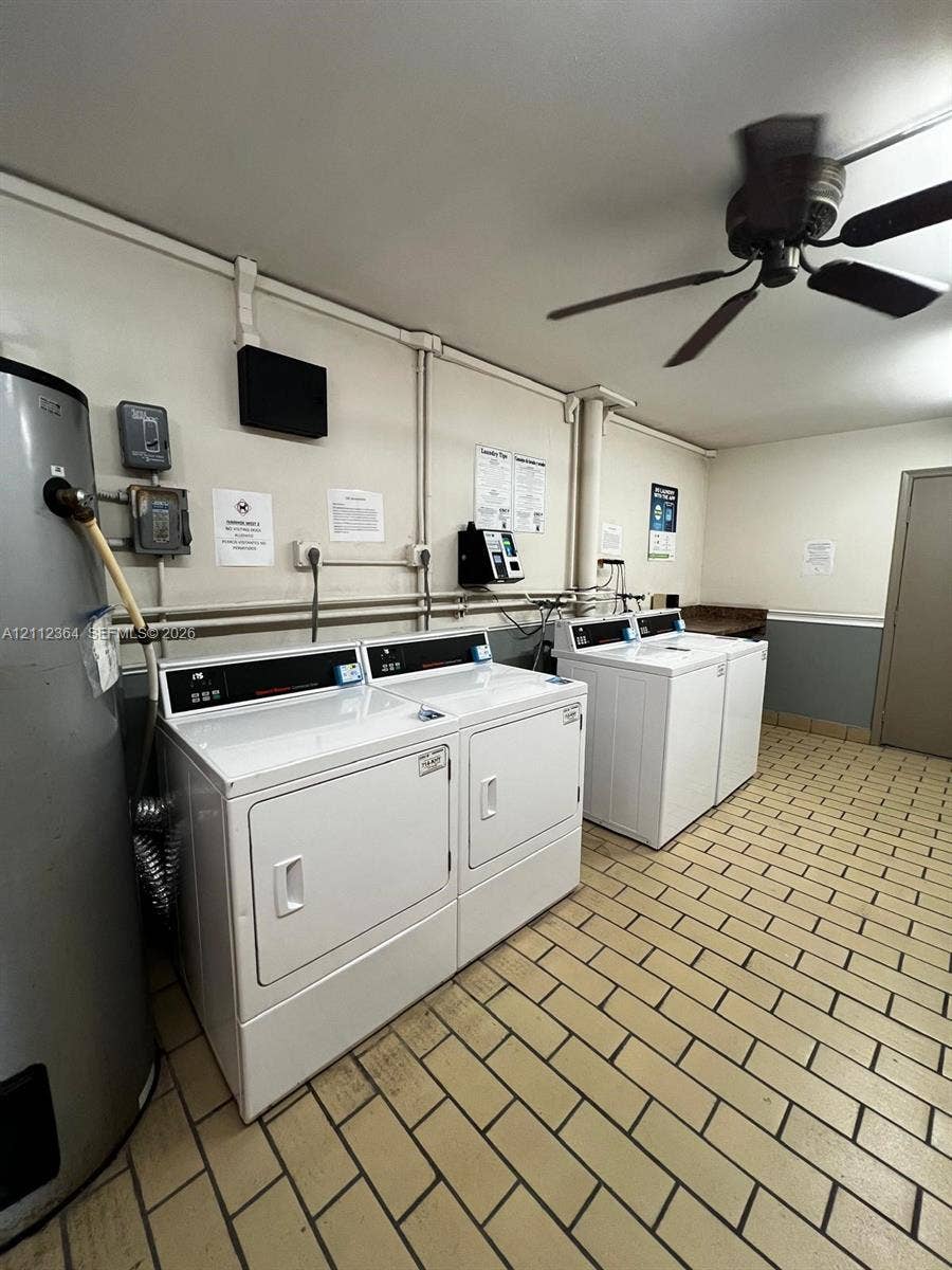 Utility area featuring ceramic tile flooring, two commercial-grade laundry sets, and a ceiling-mounted fan