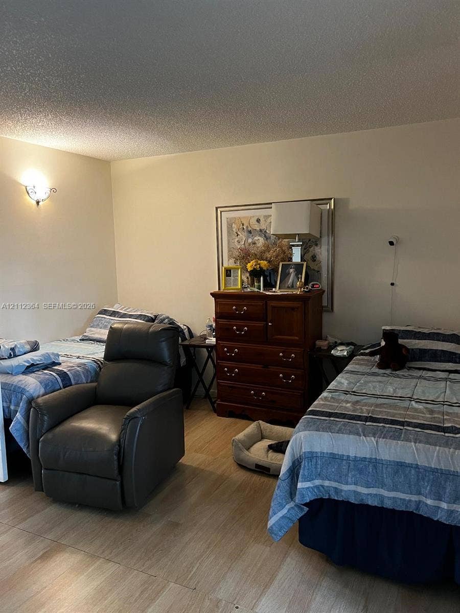 Room interior featuring light-tone wood-finish flooring and a wall-mounted decorative sconce