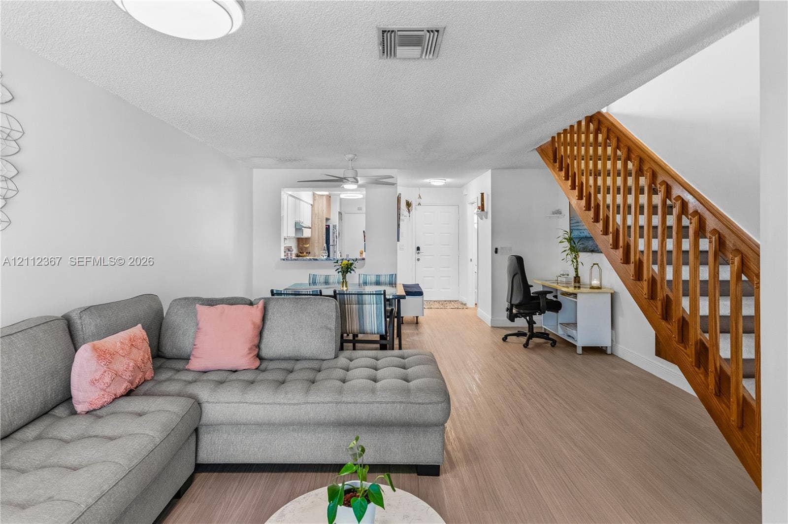 10803 Cypress Glen Drive, #10803, Coral Springs, FL 33071 Wood-finish flooring, staircase with wood railings and balusters, and kitchen pass-through window