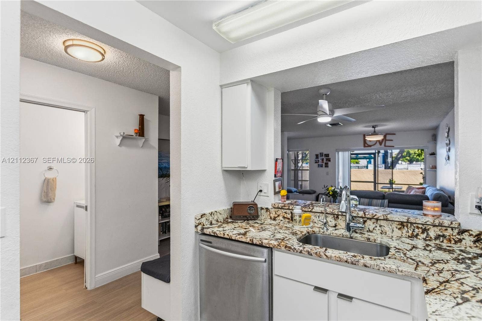 10803 Cypress Glen Drive, #10803, Coral Springs, FL 33071 Kitchen featuring stone countertops, stainless steel undermount sink with pull-down faucet, stainless steel dishwasher, and white cabinetry