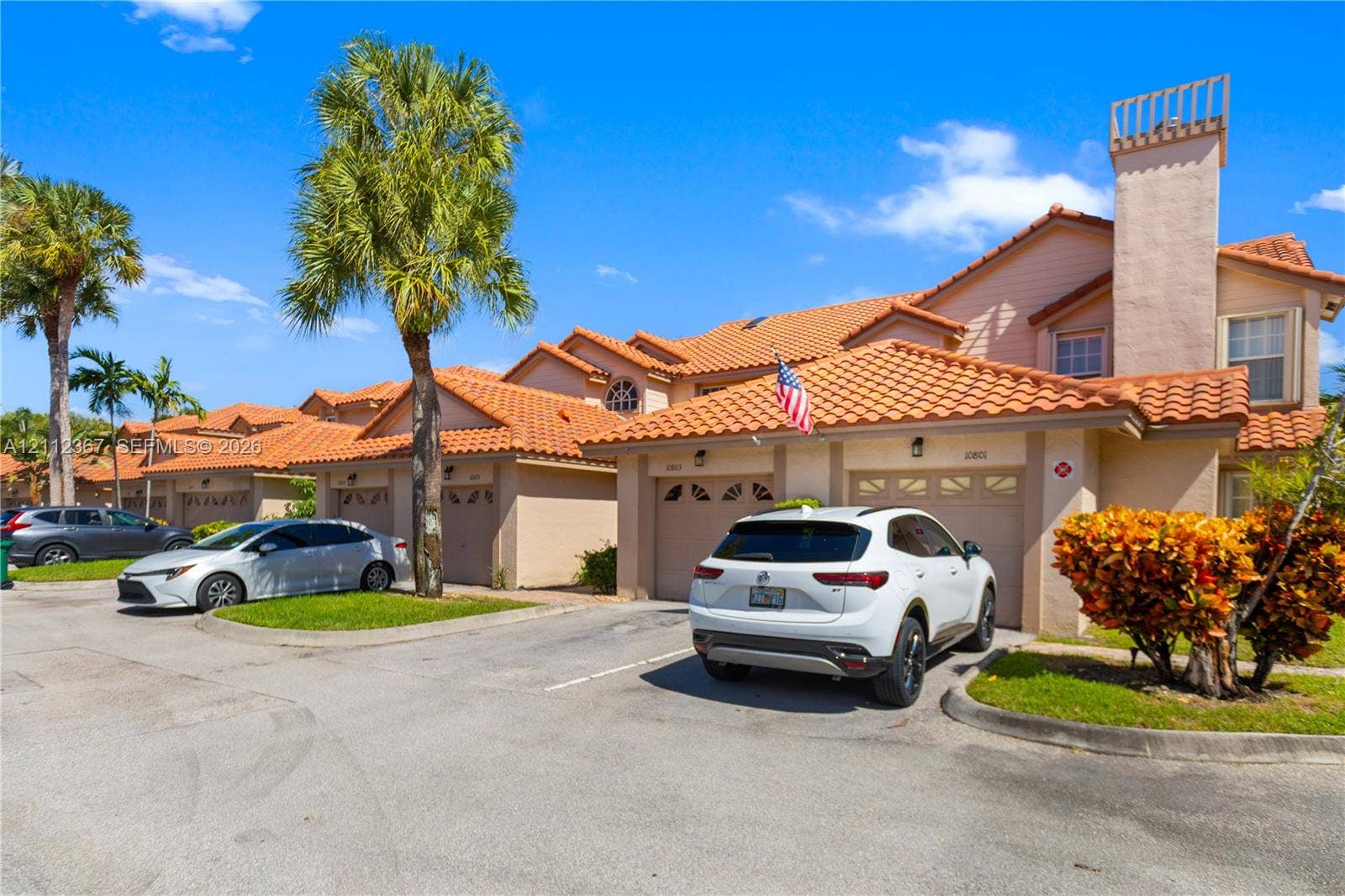 10803 Cypress Glen Drive, #10803, Coral Springs, FL 33071 Stucco exterior featuring a clay tile roof, attached garage, and prominent chimney structure