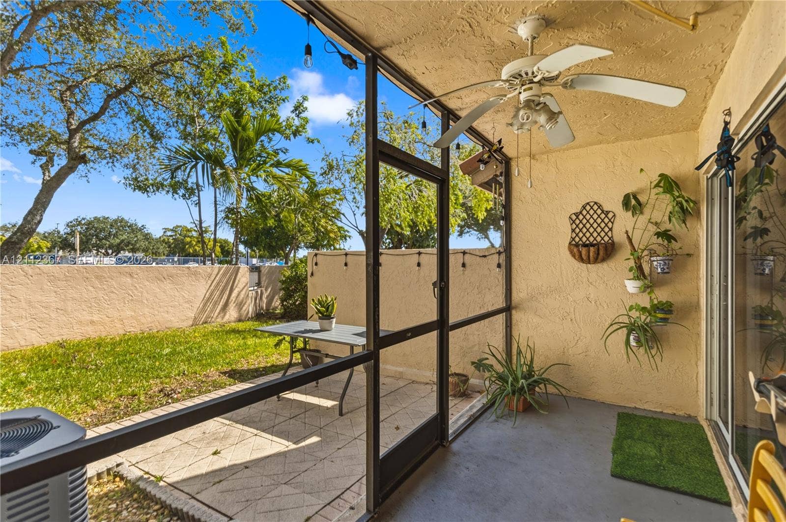 10803 Cypress Glen Drive, #10803, Coral Springs, FL 33071 Screened-in patio featuring a concrete floor, ceiling fan, and masonry wall enclosure