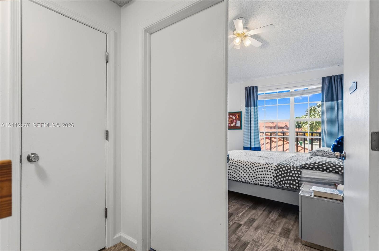 10803 Cypress Glen Drive, #10803, Coral Springs, FL 33071 Room interior featuring wood-finish flooring, a multi-pane window, and an attached ceiling fan with light fixture
