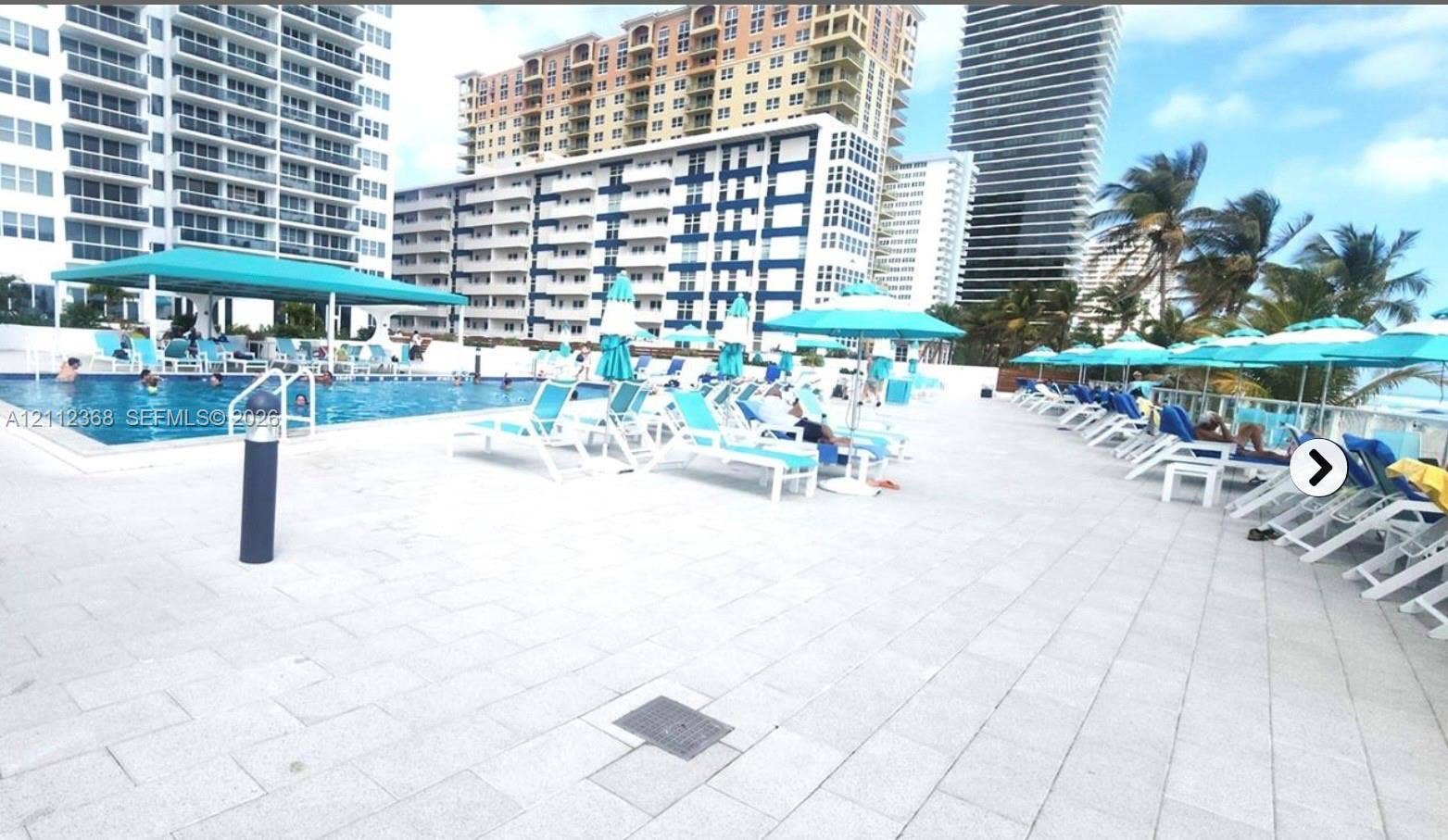 Swimming pool with a covered pavilion area and stone-paved sun deck