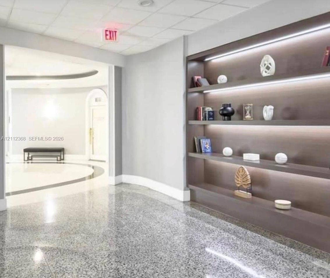 Built-in floor-to-ceiling shelving featuring integrated LED accent lighting and polished stone flooring
