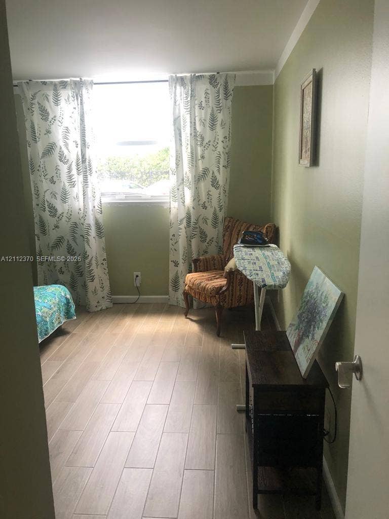 Room featuring wood-finish tile flooring and a large rectangular window