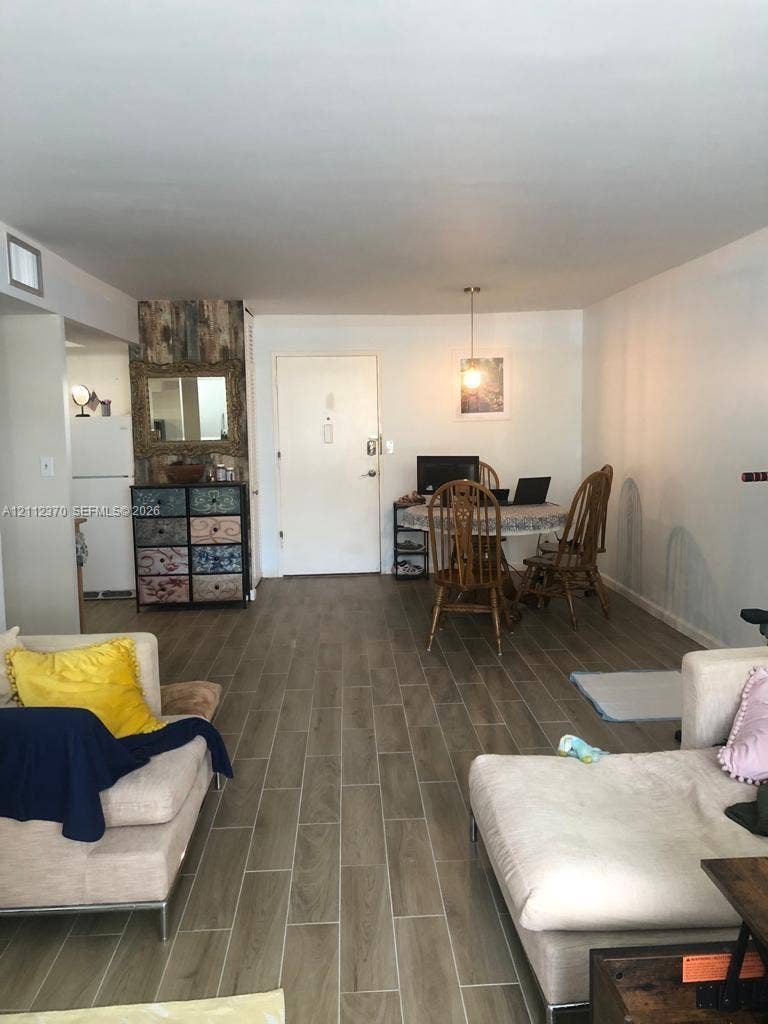Open-concept interior featuring wood-finish tile flooring and a dedicated pendant light fixture
