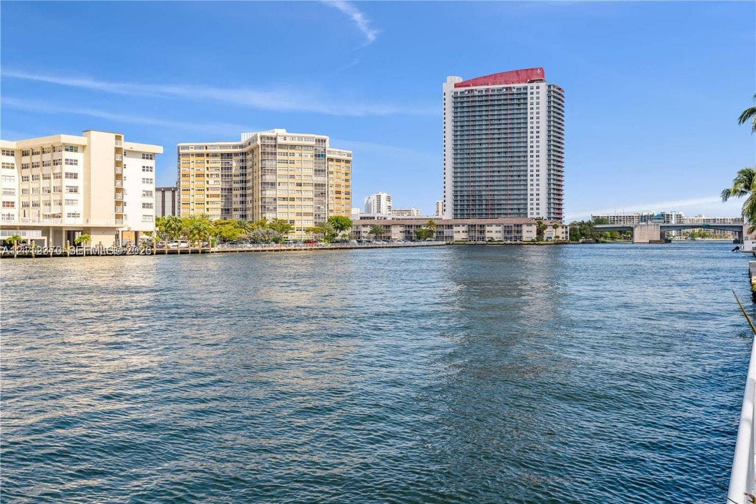 Waterfront perspective featuring a waterway with multi-story residential architecture and bridge infrastructure