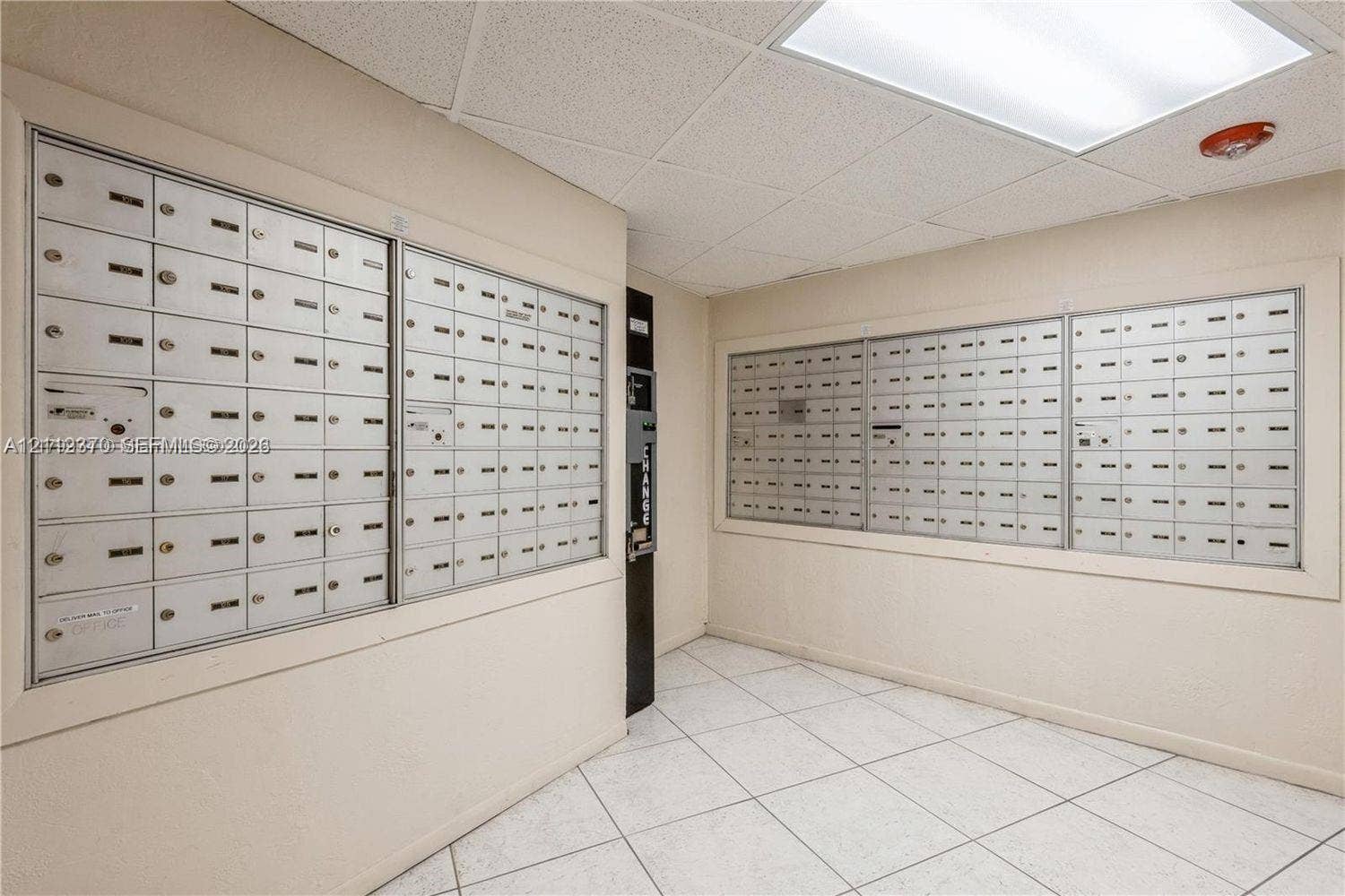 Mailroom featuring wall-mounted metal mailboxes and tiled flooring