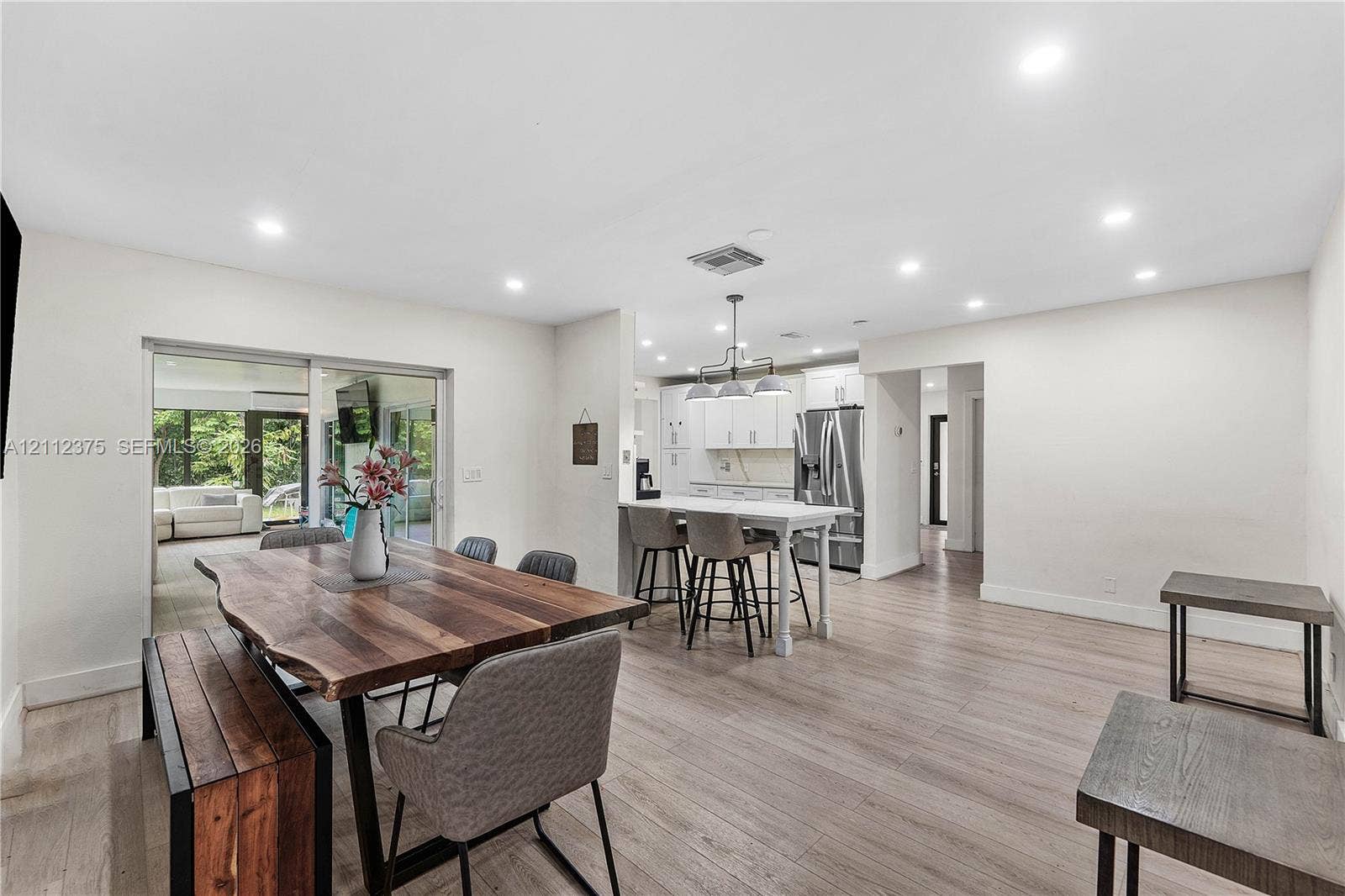 10936 NW 41st Drive, Coral Springs, Coral Springs, FL 33065 Open concept space featuring recessed lighting, wood-finish flooring, a kitchen island with built-in cabinetry, and sliding glass doors