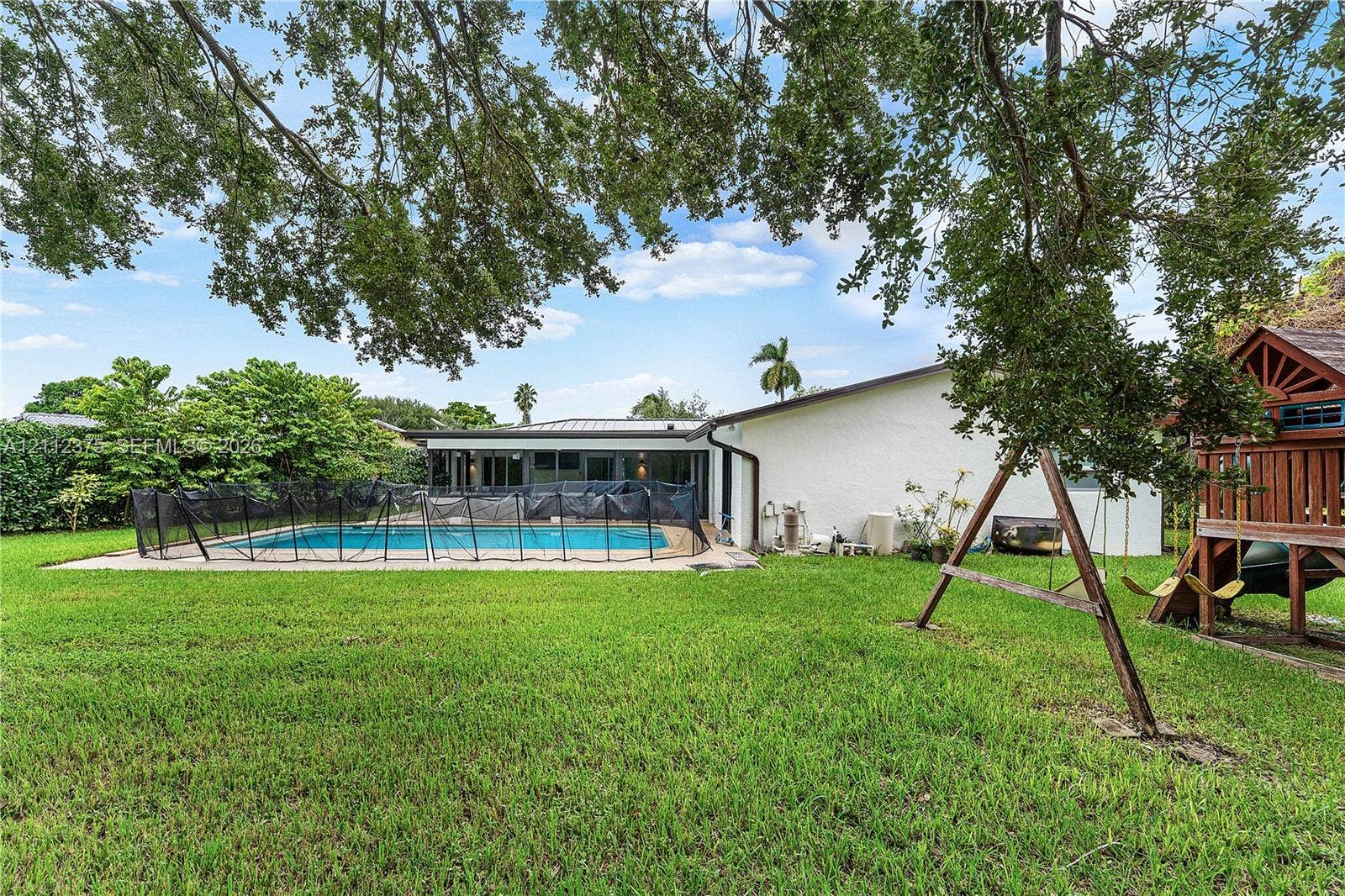 10936 NW 41st Drive, Coral Springs, Coral Springs, FL 33065 Expansive backyard featuring a concrete-surround swimming pool and mature shade trees