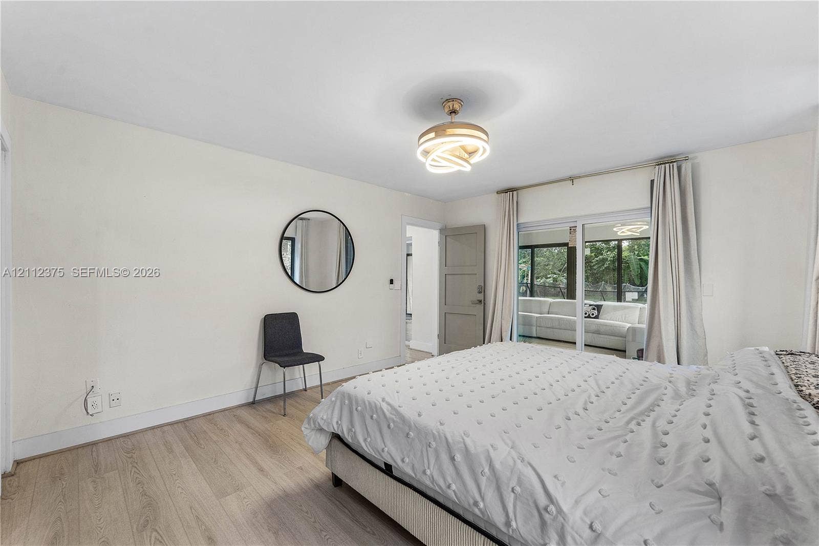 10936 NW 41st Drive, Coral Springs, Coral Springs, FL 33065 Wood-finish flooring, contemporary geometric flush-mount light fixture, and floor-to-ceiling sliding glass doors