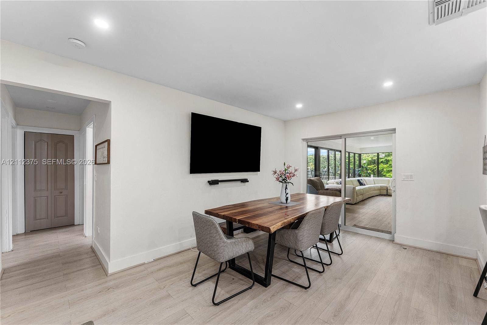 10936 NW 41st Drive, Coral Springs, Coral Springs, FL 33065 Neutral-toned interior featuring wood-finish flooring, recessed lighting, and a sliding glass door